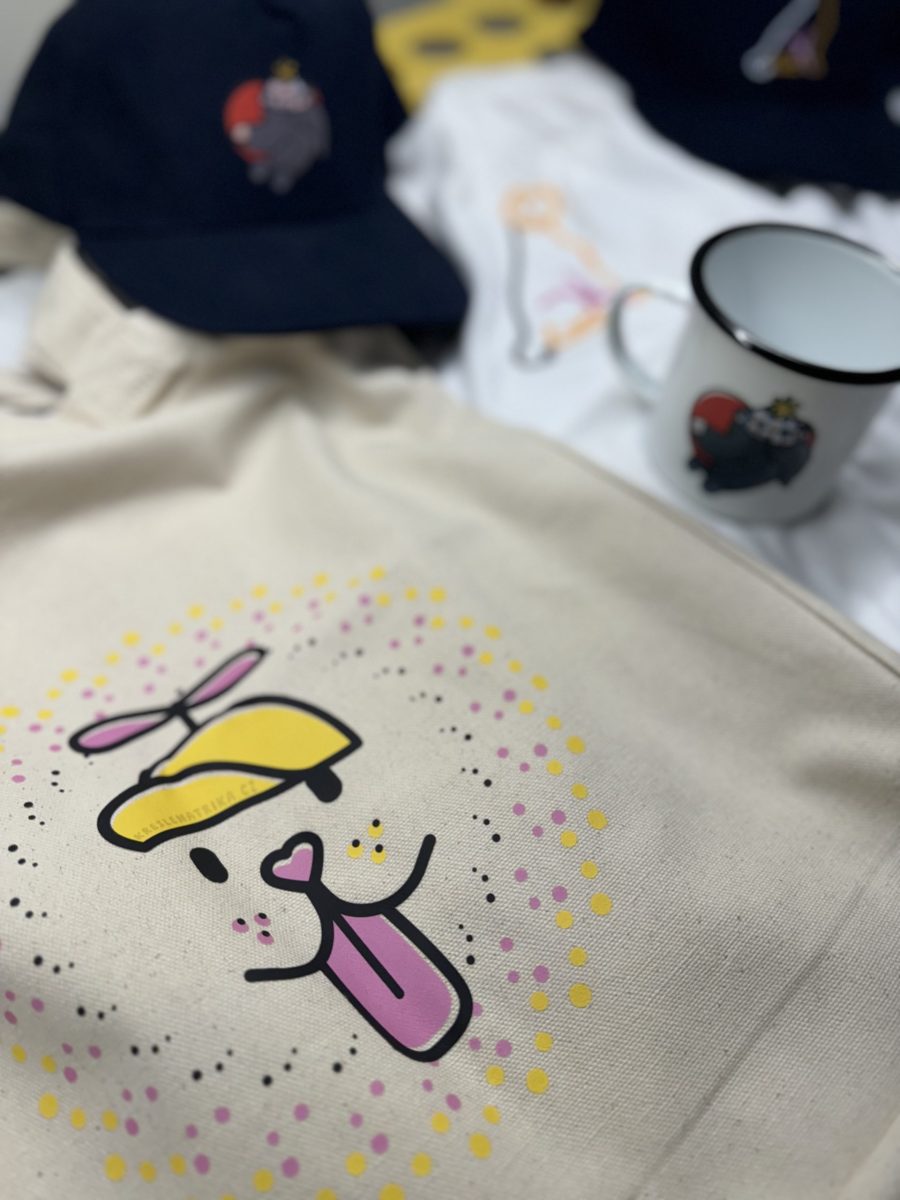 Reálné tisky na různé materiály: plátěnka, kšiltovka, tričko a plecháček s psím motivem. Všechny tyto produkty pomáhají.